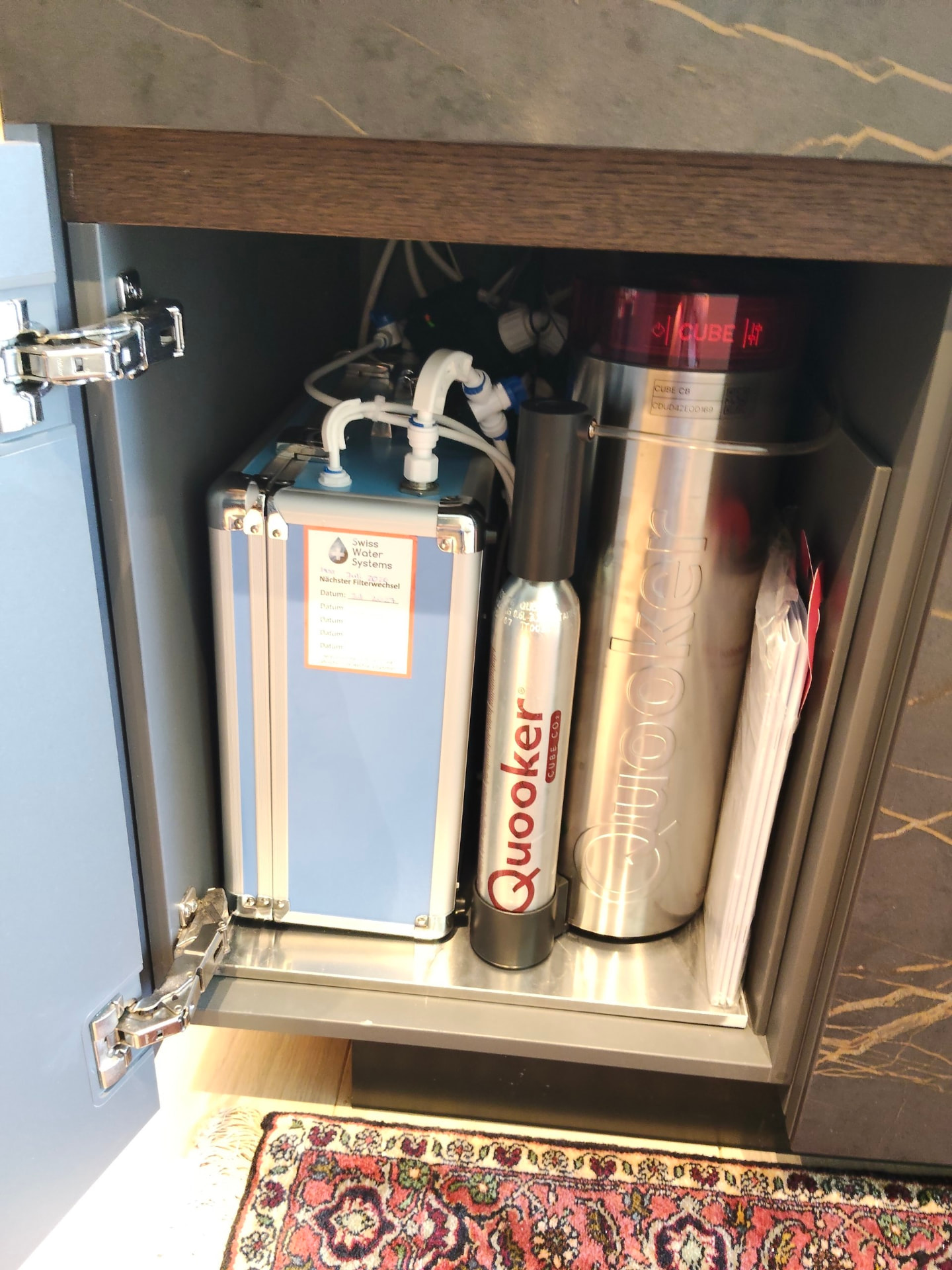Eingebautes Swiss-Water-Systems-Gerät im Unterschrank neben Quooker-Technik